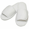 A pair of Towel City's TC067 white open-toe slippers, with one partially overlapping the other, placed on a white background.