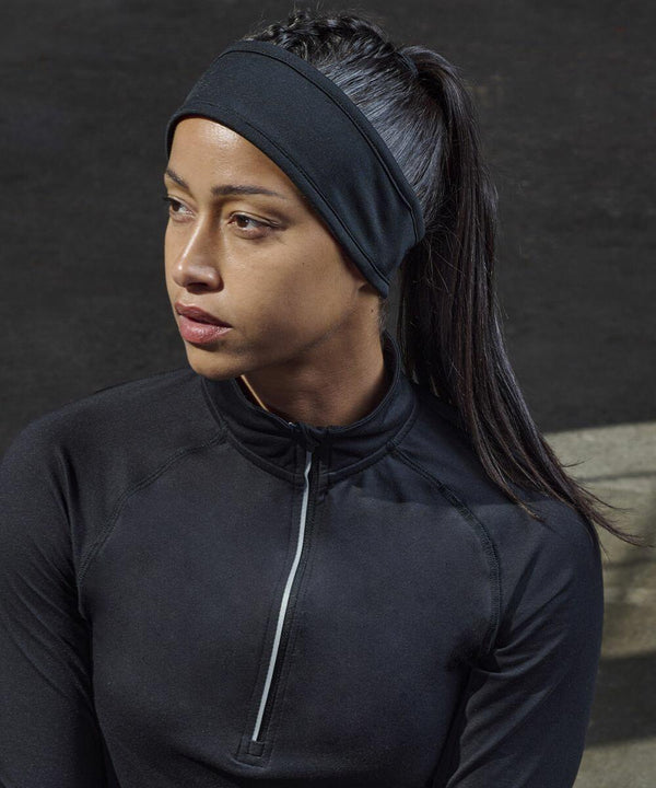 A person wearing a black Tombo TL690 and zip-up athletic top is looking to the side.