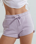 Close-up of a person's midsection wearing light purple TR063 drawstring shorts by Tri-Dri and a white top.