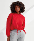 A person with curly hair wears a red Tri-Dri TR085 and gray sweatpants, standing against a white background.