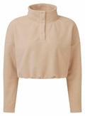 The Tri-Dri TR087 is a beige fleece pullover featuring a high collar and button closure. It has long sleeves and a relaxed fit for a cozy, comfortable appearance, with the material providing a soft, plush texture.