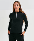Person wearing a long-sleeved black Tri-Dri TR121 with hands in pockets, standing against a plain white background.