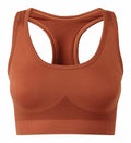 A rust-colored TR214 sports bra by Tri-Dri, featuring a racerback design and seamless detailing, is shown on a white background.