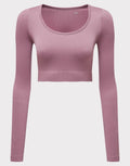 The TR224 by Tri-Dri is a pink, long-sleeved ribbed crop top with a round neckline.