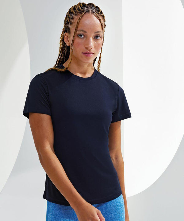 Person with long braided hair wearing a black short-sleeve TR502 shirt by Tri-Dri and blue pants, standing in front of a plain white background.