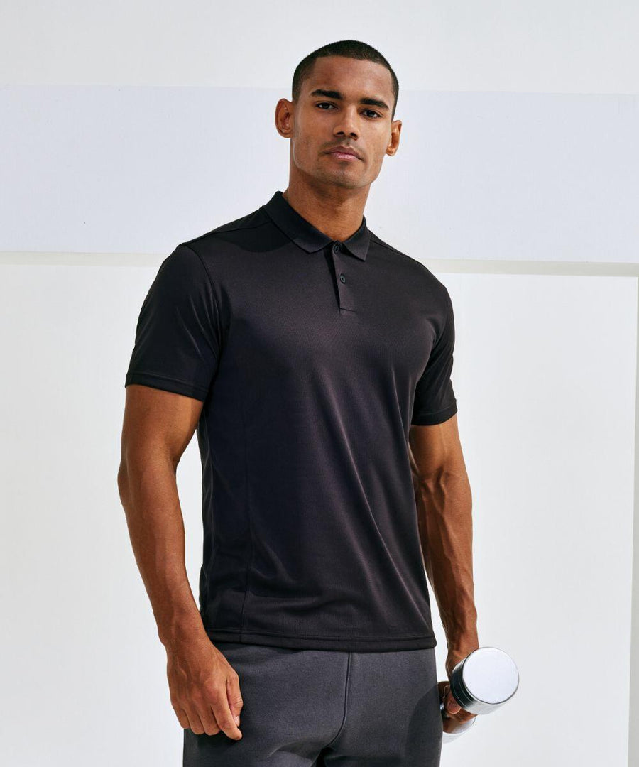 A person wearing a black polo shirt and holding a Tri-Dri TR505 stands against a plain background, looking at the camera.
