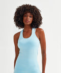 A person with curly hair wears a light blue Tri-Dri TR509 tank top, standing against a plain white background.