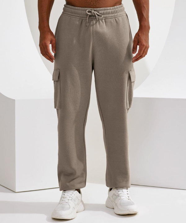 A person wearing Tri-Dri TR604 beige cargo sweatpants and white sneakers stands against a white background.