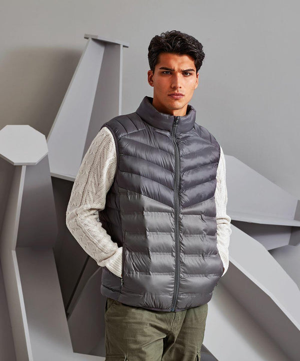 A person wearing a 2786 TS017 over a white sweater stands indoors against a geometric background.