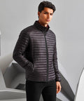 A man stands wearing a dark, quilted TS018 jacket with a zipper in front by 2786, posing against a grey background.