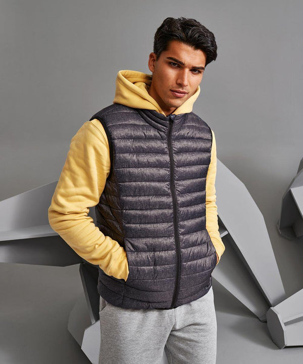A man wearing a yellow hoodie, TS038 by 2786, and gray sweatpants stands in front of a gray background.