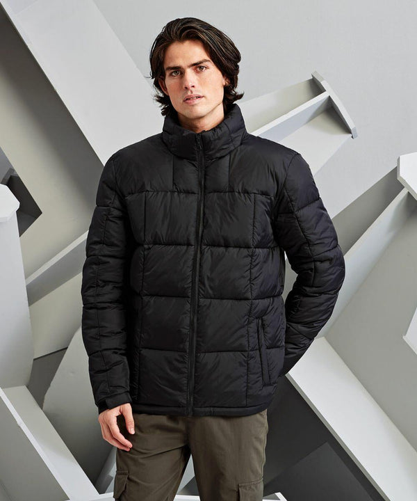A man stands against a geometric background wearing the 2786 TS048 black puffer jacket and green pants.
