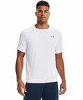 A man wearing a white short-sleeve Under Armour UA005 t-shirt and navy blue pants, standing and facing forward.