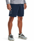 A person is shown from the waist down wearing a gray jacket, navy blue shorts with an Under Armour logo on the left thigh, and gray UA017 athletic shoes with white soles.