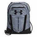 The UA051 by Under Armour is a gray drawstring backpack featuring a black logo and lettering, complete with a front zip pocket and adjustable straps.
