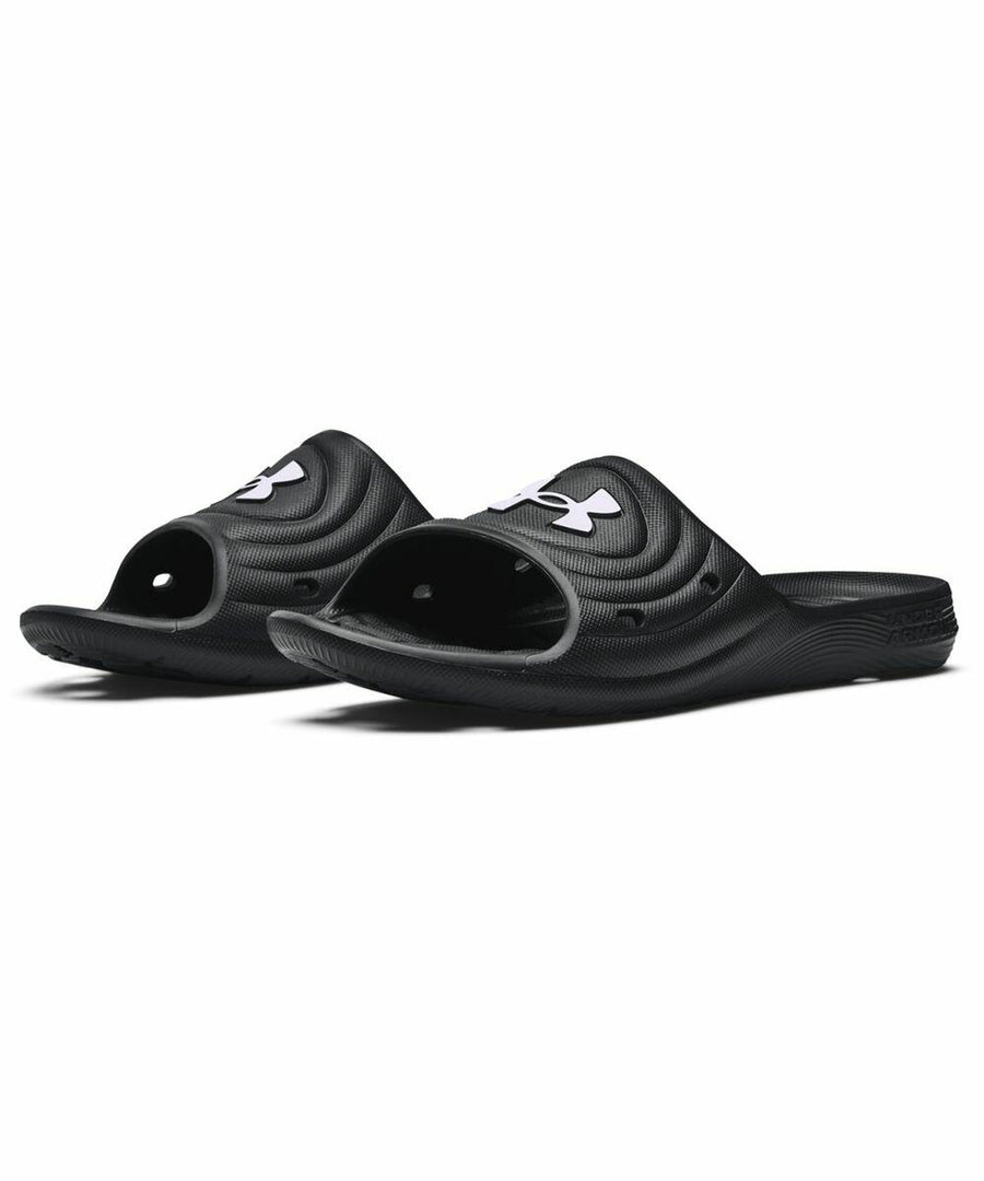 A pair of black open-toe slides with a contoured footbed and the Under Armour logo on the strap, called UA054 by Under Armour.