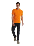 A man wearing a UC101 Orange Uneek classic polo shirt with Black trousers