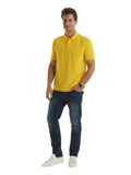 A man wearing a UC102 Yellow Uneek heavyweight polo shirt with Blue jeans