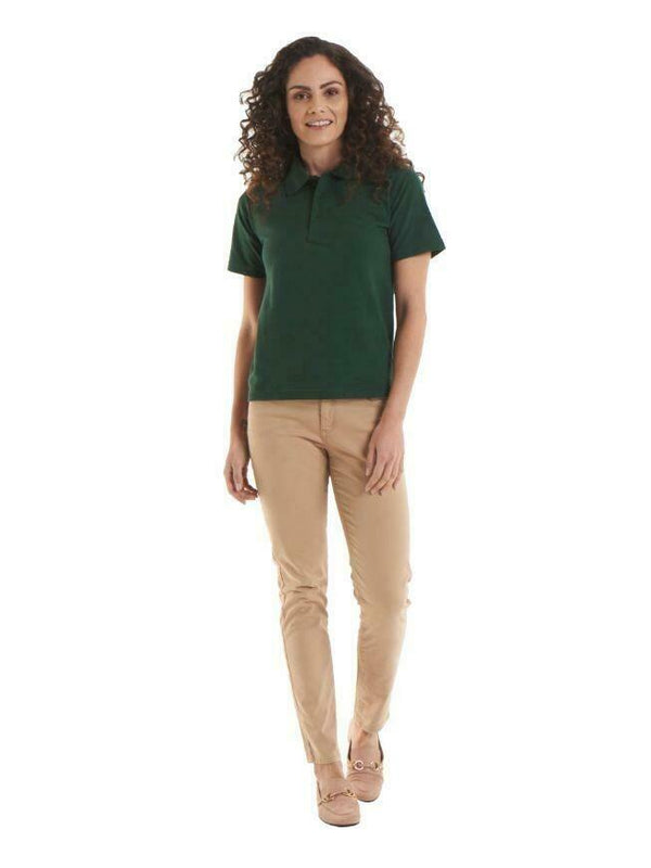 A woman wearing a UC105 Bottle Green Uneek active pique polo shirt with Beige trousers