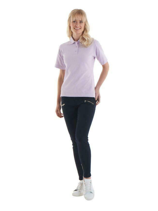 A woman wearing a UC106 Lilac Uneek ladies polo shirt with Black trousers