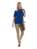 A woman wearing a UC108 Royal Uneek deluxe polo shirt with Beige trousers