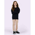 A girl wearing a UC203 Black Uneek Classic Childrens sweatshirt in with Beige trousers