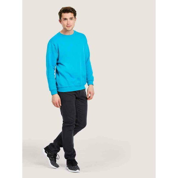 A man wearing a UC203 Sapphire Blue Uneek classic round-neck sweatshirt with Black Chinos