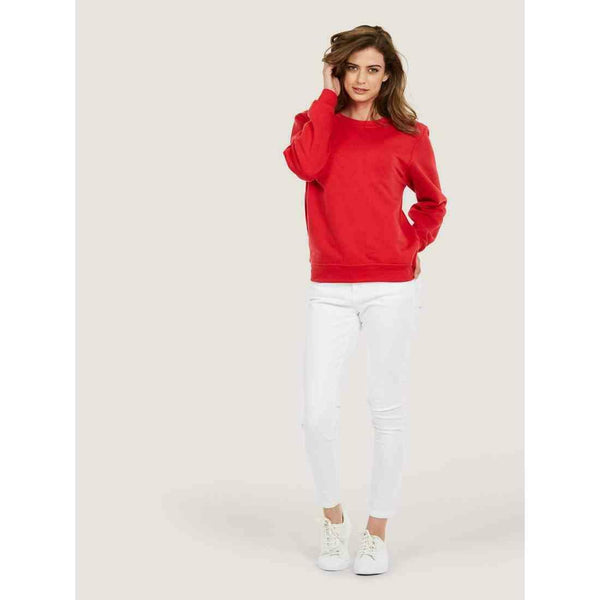 A woman wearing a UC205 Red Uneek olympic sweatshirt with White jeans