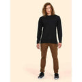 A man wearing a UC314 Black Uneek L/S classic t-shirt with Brown trousers