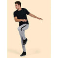 A man wearing a UC315 Black Uneekmens ultra cool t-shirt with Grey tracksuit bottoms