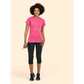 A woman wearing a UC318 Hot Pnk Uneek ladies classic crew neck t-shirt with Black shorts