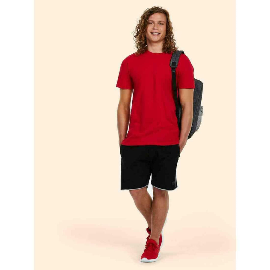 A man wearing a UC320 Red Uneek olympic t-shirt with Black shorts