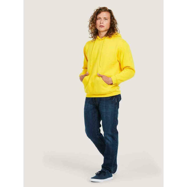 A man wearing a UC502 Yellow Uneek adults classic hoodie with Blue jeans