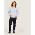 A man wearing a UC504 Heather Grey Uneek adults classic full zip hoodie with Blue jeans