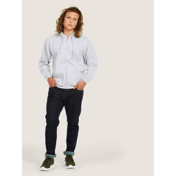 A man wearing a UC504 Heather Grey Uneek adults classic full zip hoodie with Blue jeans
