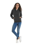 A women with long wavey hair wearing a Uneek Ladies Deluxe Hooded Sweatshirt in Charcoal with blue jeans and white trainers on a white background