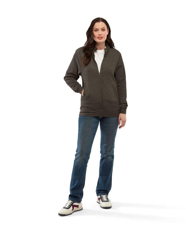 A woman wearing a Uneek UC203 unisex deluxe sweat jacket in Charcoal with blue jeans and white trainers