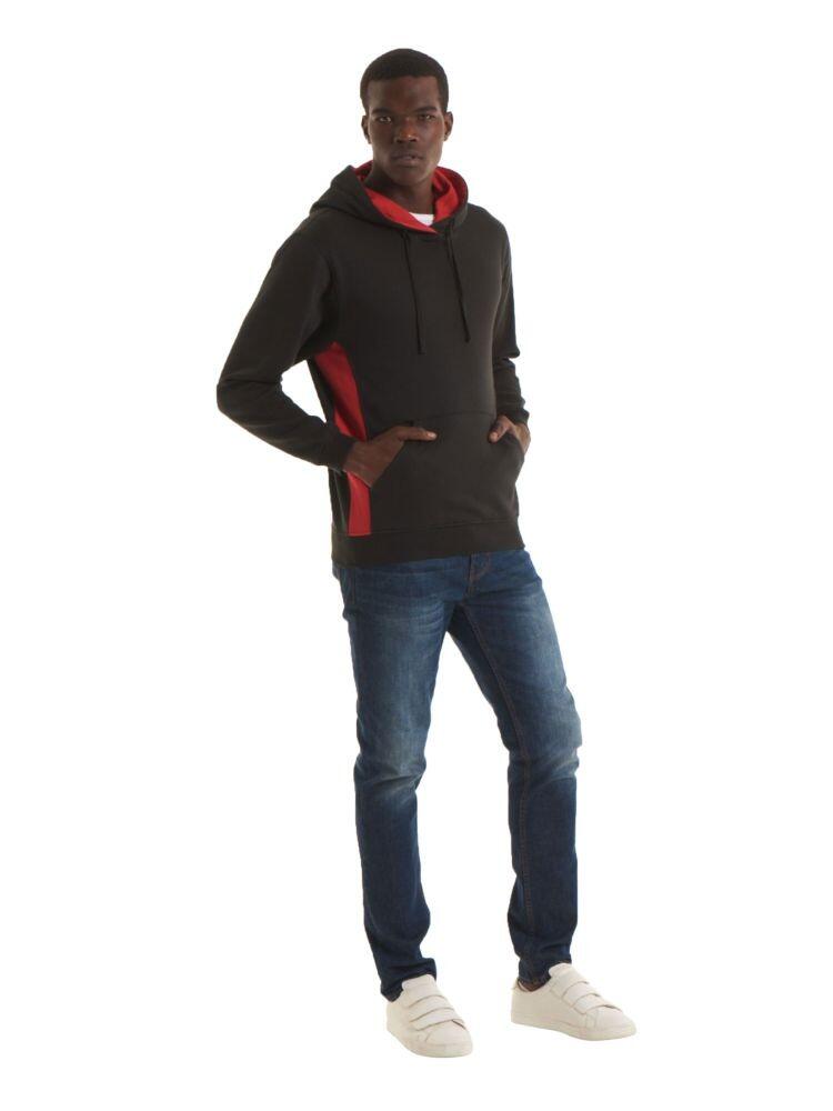 A man wearing a Uneek Two Tone Hooded Sweatshirt in Black and Red and Blue Jeans on a white background
