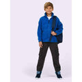A boy wearing a UC603 Royal Uneek childrens full zip micro fleece jacket with Black combats