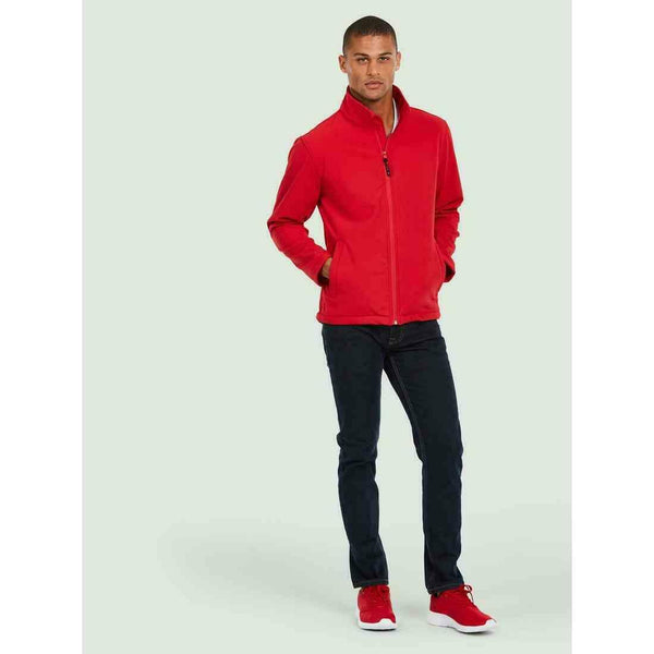 A man wearing a UC612 Red Uneek classsic soft shell jacket with Blue jeans
