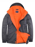 A Uneek UC621 Deluxe Outdoor Jacket in Deep Grey & Fiery Orange on a white background