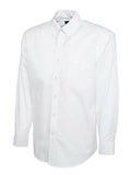 A white Uneek UC701 button-up shirt with long sleeves and a collar, displayed on a plain background.