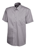 UC702 Charcoal button-up short-sleeved shirt by Uneek displayed on a white background, featuring a pointed collar and a left chest pocket.
