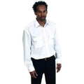 A man in a white button-up shirt and black pants, standing with a serious expression wearing Uneek's UC707.