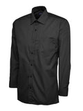A black, long-sleeved UC709 dress shirt with a button-up front and a single chest pocket, displayed on a plain background by Uneek.