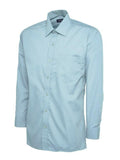 A light blue, long-sleeved UC709 dress shirt with a button-up front and a single chest pocket, displayed on a plain background by Uneek.