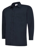 A navy, long-sleeved UC709 dress shirt with a button-up front and a single chest pocket, displayed on a plain background by Uneek.