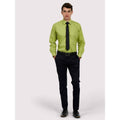 A man wearing a UC709 Lime Green Uneek poplin Long Sleeved shirt with Black trousers