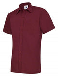 A burgundy, short-sleeved UC710 dress shirt with a button-up front and a single chest pocket, displayed on a plain background by Uneek.