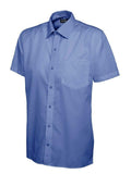A mid blue, short-sleeved UC710 dress shirt with a button-up front and a single chest pocket, displayed on a plain background by Uneek.